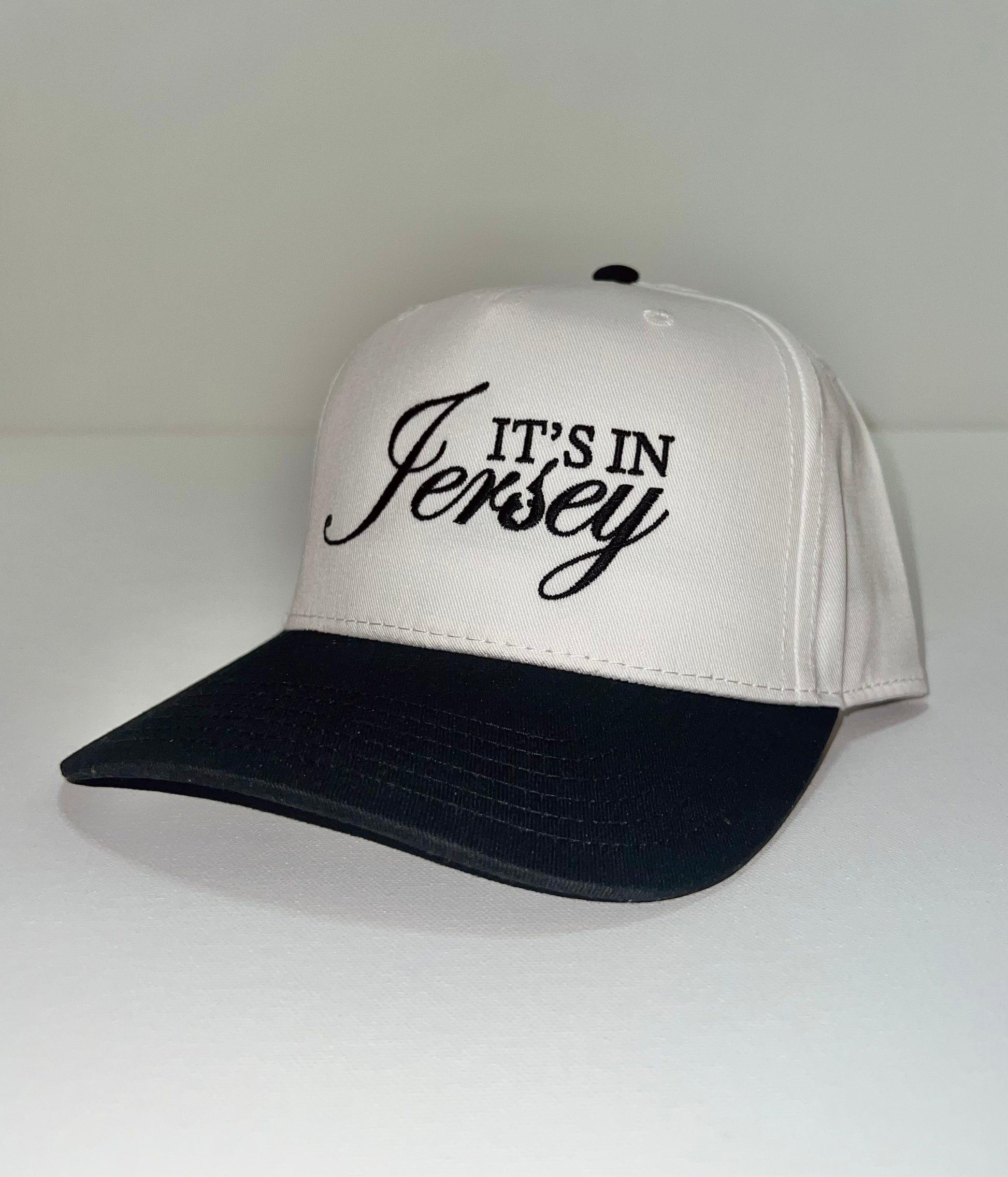 White snapback with black bill and 'It's in Jersey' embroidery