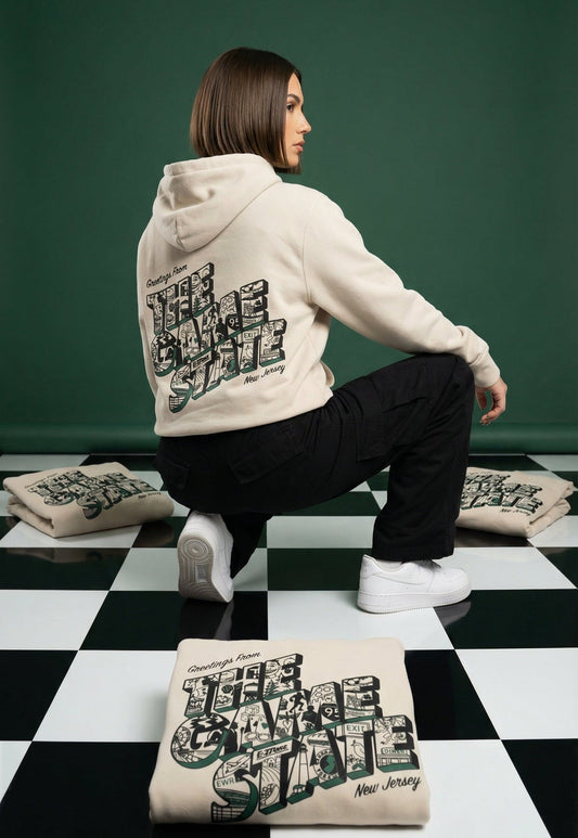 Woman wearing a hoodie with The Game State kneeling on a checkered floor with similar text bags.